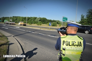Policjant drogówki podczas sprawdzania prędkości jadących pojazdów.