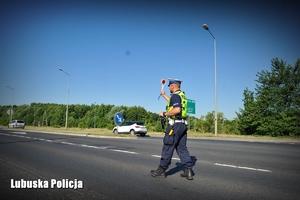Policjant drogówki podczas zatrzymywania pojazdu do kontroli drogowej.