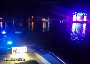 Policyjna motorówka na wodzie nocną porą
