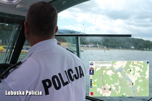 policjant obserwujący plażowiczów i krajowa mapa zagrożeń bezpieczeństwa