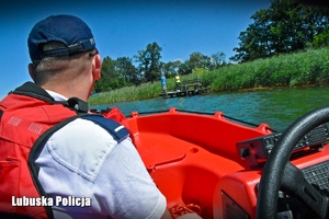 Policjant obserwuje nabrzeże z łodzi