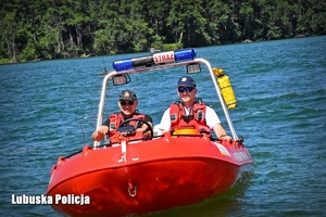 Policjant i strażak w łodzi motorowej