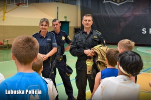 Policjantka, strażak i strażnik miejski rozmawiają z dziećmi