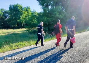 Policjanci oraz strażak z psem służbowym podczas poszukiwań.