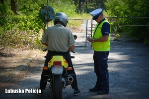 Policjant kontroluje motocyklistę