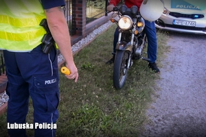 Policjant kontroluje motorowerzystę