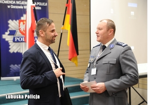 Policjant rozmawia z mężczyzną podczas konferencji miedzynarodowej
