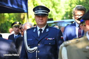 Inspektor Jarosław Pasterski na uroczystości stojący wśród innych osób.