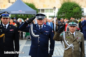 Inspektor Jarosław Pasterski oddaje honor wraz z innymi funkcjonariuszami.