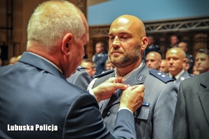 Wojewoda Lubuski Władysław Dajczak wręcza odznaczenie policjantowi.