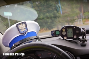 Czapka policjanta ruchu drogowego oraz miernik prędkości na kokpicie radiozowu