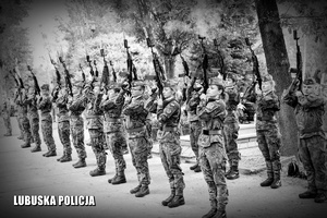 Zdjęcie czarno - białe: salwa honorowa wystrzeliwana przez żołnierzy.