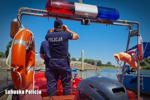 Policjanci na łodzi obserwują wodę