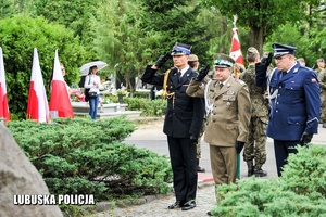 Funkcjonariusze służb mundurowych oddają honory przed pomnikiem.