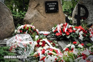 Pomnik Pamięci Armii Krajowej, a przed nim znicze i wiązanki kwiatów.