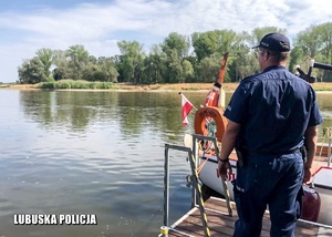 Policjant obserwuje rzekę z przystani