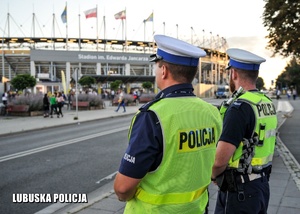 Policjanci drogówki, a w tle stadion żużlowy.