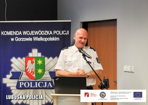 Policjant z Niemiec przemawiający z mównicy.