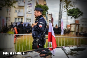 Flaga Polski i policjant w tle
