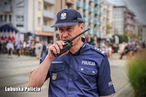 Policjant podaje komunikat przez radiostację