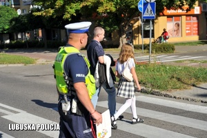 policjant pomaga przejść przez przejście dla pieszych