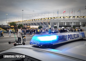 Policyjne sygnały błyskowe radiowozu na tle stadionu żużlowego