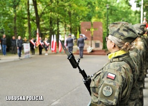 Kompania żołnierzy stojąca na tle pomnika.