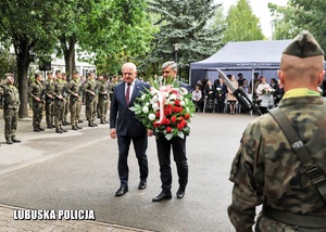 Wojewoda Lubuski wraz z Dyrektorem Generalnym Lubuskiego Urzędu Wojewódzkiego składa kwiaty przed pomnikiem.