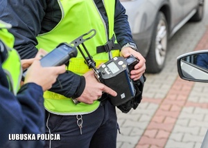 Laserowy miernik prędkości w dłoniach policjanta.