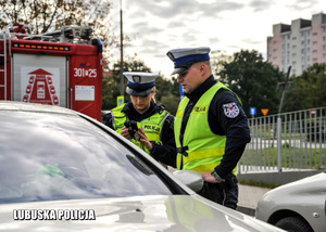 Policjanci drogówki podczas legitymowania kierującego pojazdem.