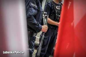 policjanci na tle flag Polski