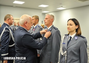Wojewoda Lubuski przypina medal policjantowi.