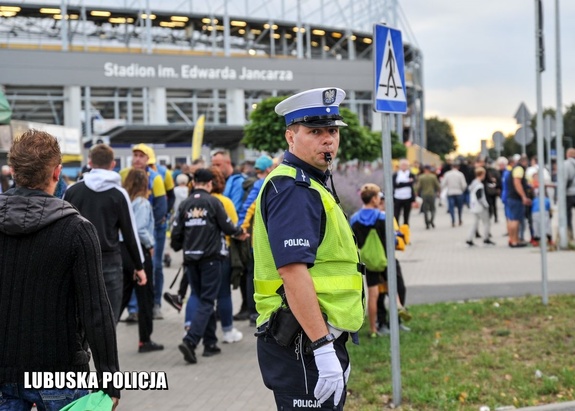 policjant stoi obok stadionu