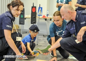 Policjanci podczas układania puzzli wraz z chłopcem.