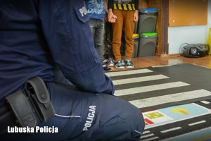 Policjant uczy dzieci prawidłowego przejścia przez pasy