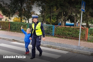 Policjantka pomaga przejść chłopcu przez jezdnię