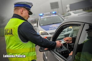 policjant kontroluje dokumenty kierowcy