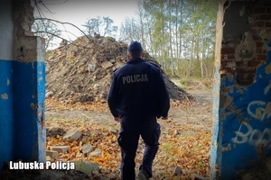 Policjant sprawdza okolice pustostanu