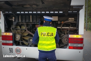 Policjantka sprawdza komorę silnika autokaru