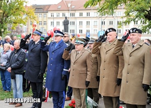 Funkcjonariusze i żołnierze oddają honor podczas hymnu państwowego.