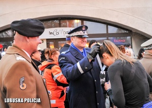 Komendant Wojewódzki Policji w Gorzowie Wielkopolskim wręcza medal kobiecie.