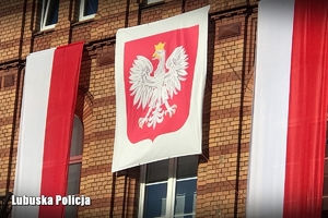 Godło Polski oraz flagi na budynku
