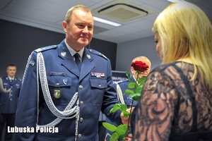 policjant wręcza różę kobiecie