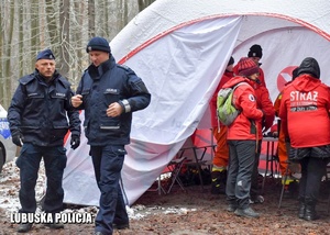 Policjanci i ratownicy przy namiocie podczas ćwiczeń sztabowych.