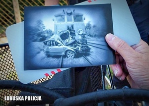 Osoba trzymające zdjęcie z wypadku drogowego.