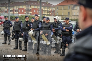 Policjanci oddziałów prewencji stojący w rzędzie podczas ćwiczeń.