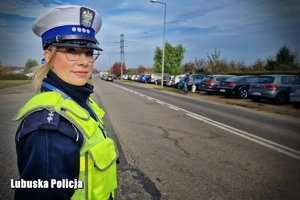 Policjantka obserwuje ruch pojazdów przy cmentarzu