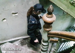 Policjantka schodzi po schodach w opuszczonym budynku