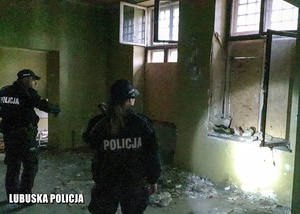 Policjant i policjantka sprawdzają pomieszczenia budynku