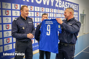 Policjant wręcza koszulkę Komendantowi Wojewódzkiemu Policji.